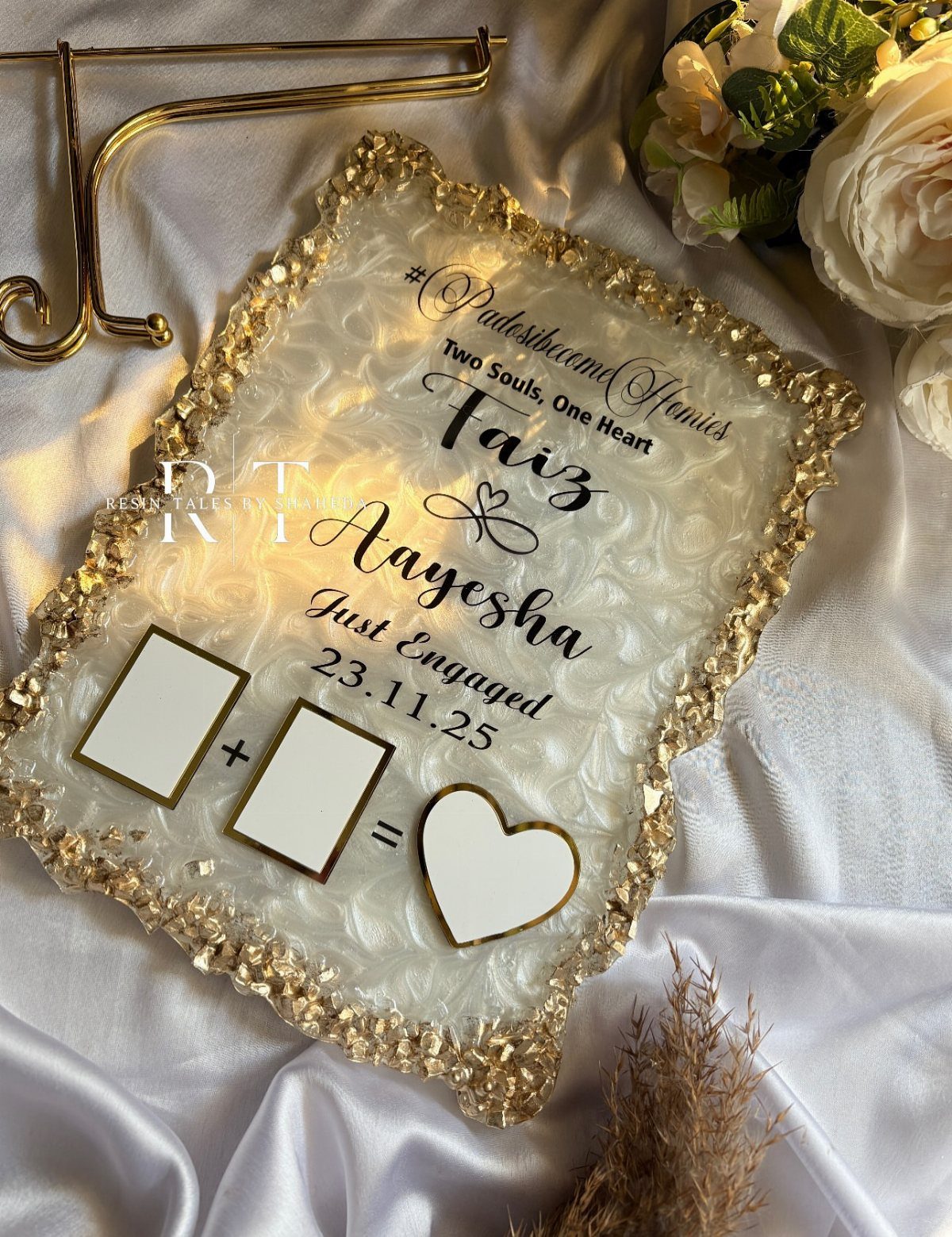 Resin engagement plaque with gold glitter edges and personalized text on white satin.