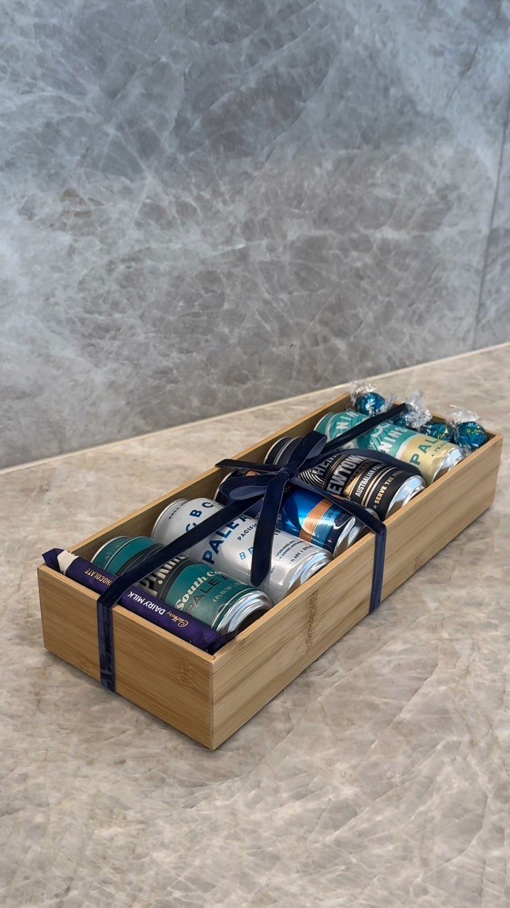 22 Gift Ideas for Brother, From Hoodies to Gadgets 6 Wooden gift box filled with craft beer cans and treats tied with blue ribbon.