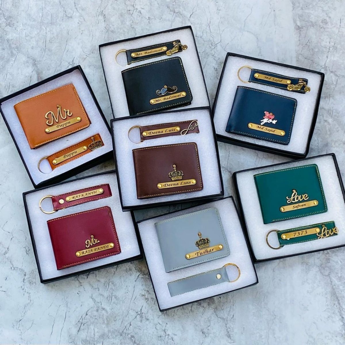 22 Gift Ideas for Brother, From Hoodies to Gadgets 5 Six personalized leather wallets and keychains in various colors displayed in gift boxes.