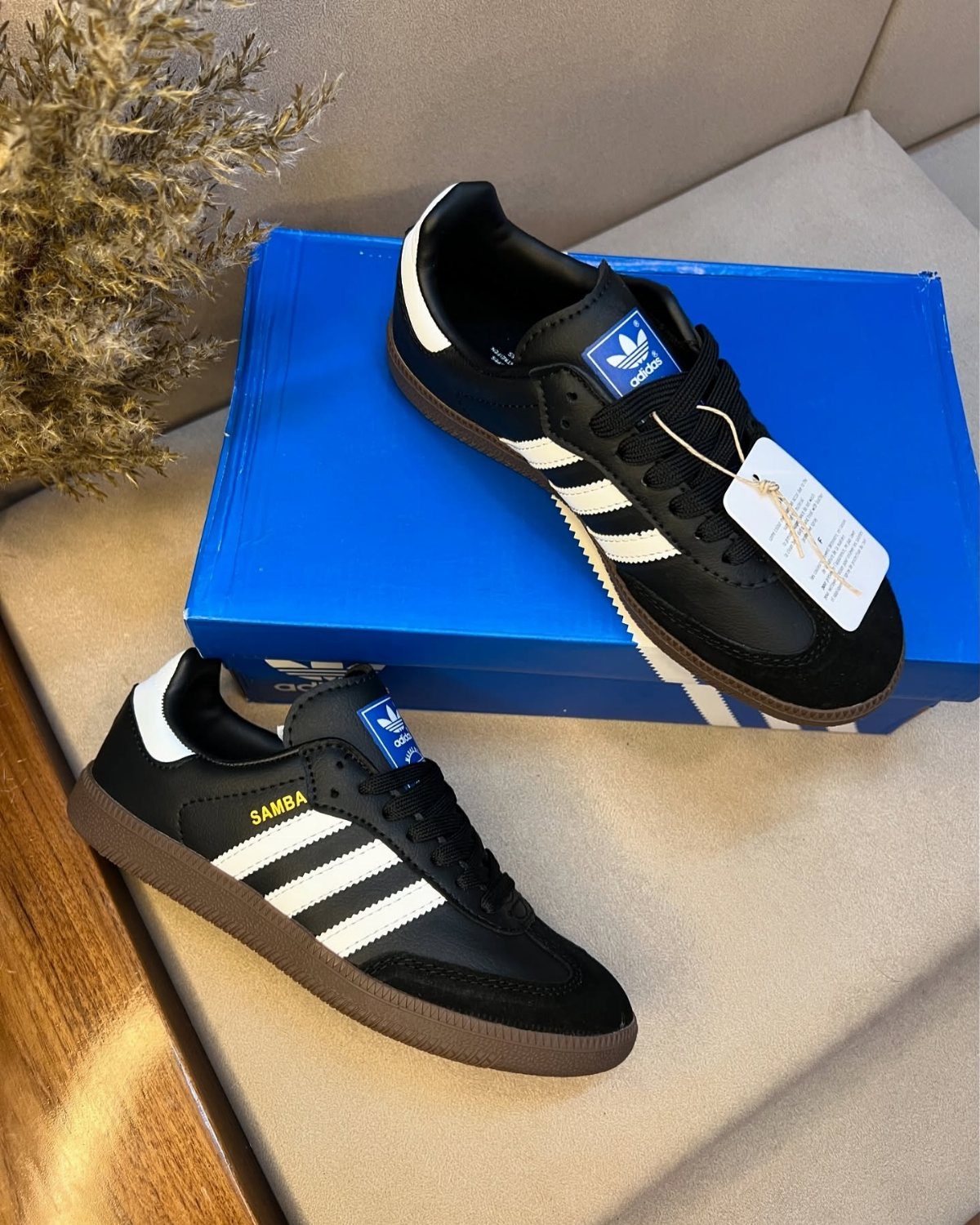 22 Gift Ideas for Brother, From Hoodies to Gadgets 3 Black Adidas Samba sneakers with white stripes on a blue shoebox