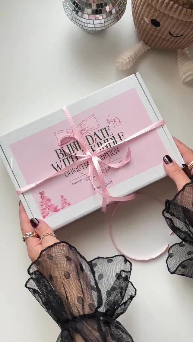 Hands holding a pink and white gift box labeled Blind Date with a Kindle.