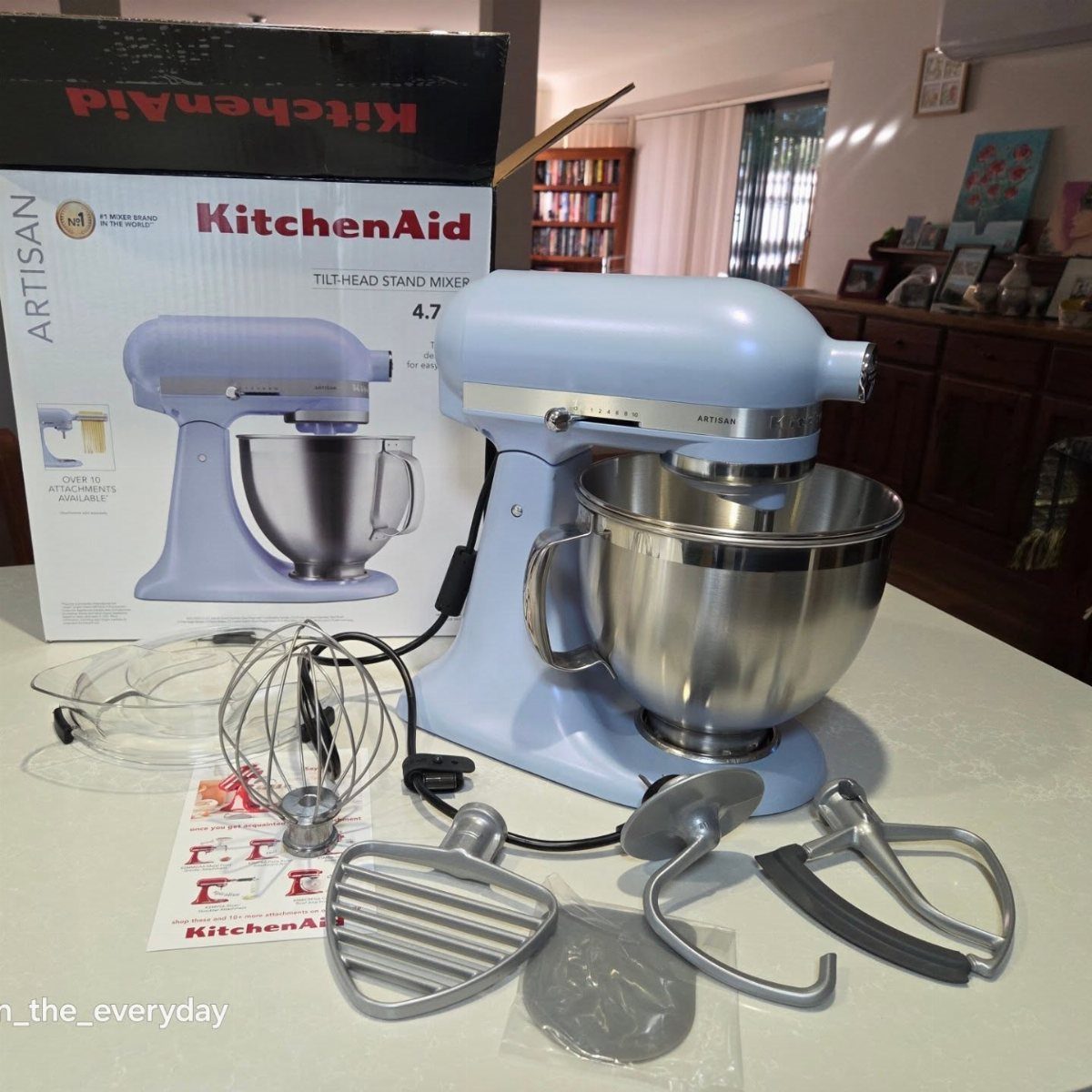 Light blue KitchenAid stand mixer with stainless steel bowl and mixing attachments.