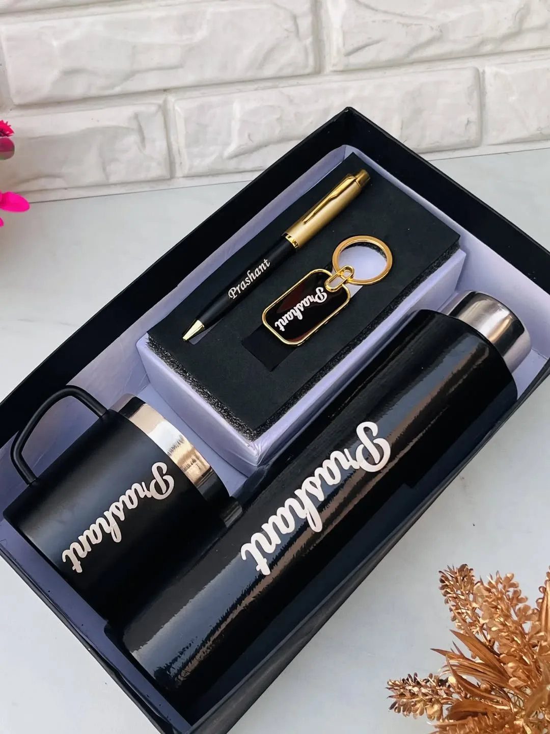 Personalized black gift set with flask, mug, pen, and keychain in a box.