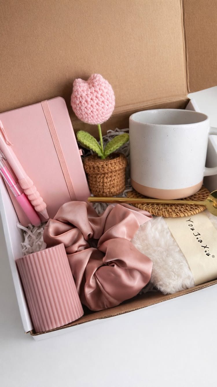 8 Gifts for People Who Have Everything 7 Curated gift box containing pink stationery, a crochet flower, and a white mug.