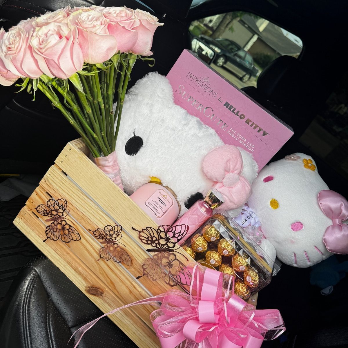Gift crate with pink roses, Hello Kitty plush, chocolates, and beauty products.