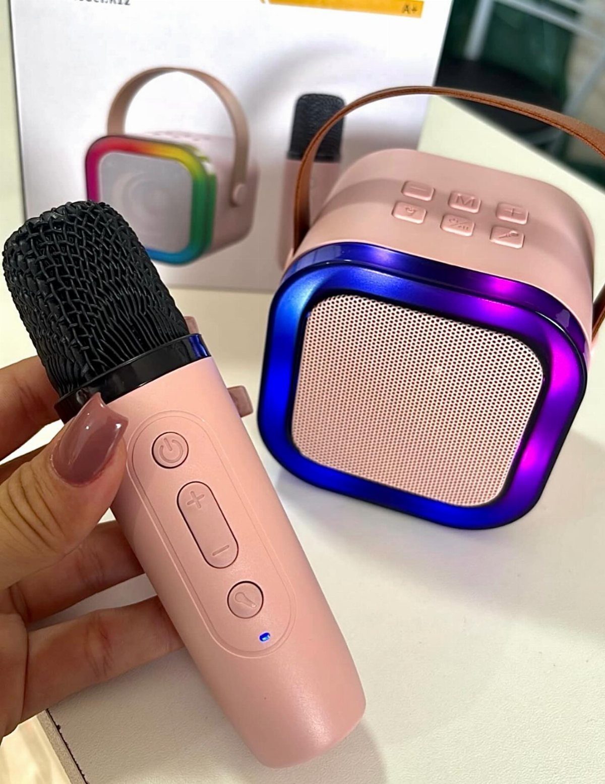 Pink handheld karaoke microphone and matching square Bluetooth speaker with colorful LED lights