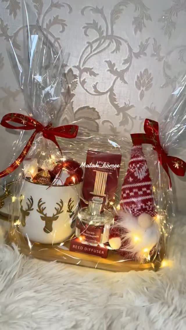 Christmas gift hamper with reindeer mug, reed diffuser, and Santa hat in cellophane