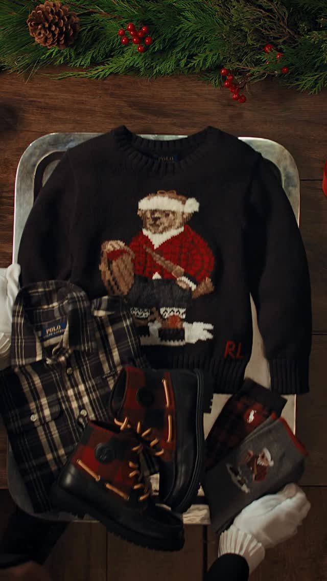 Black children's sweater with a festive teddy bear, plaid shirt, and black boots.