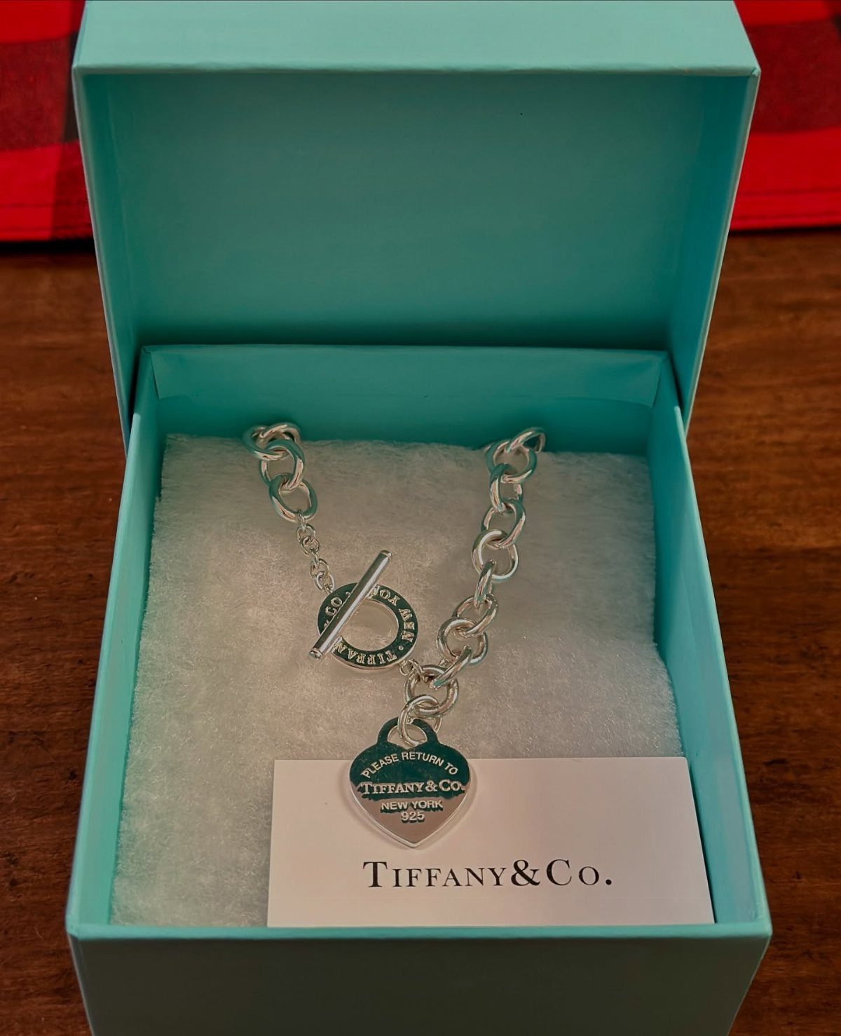Silver Tiffany and Co. heart charm bracelet inside a turquoise jewelry box