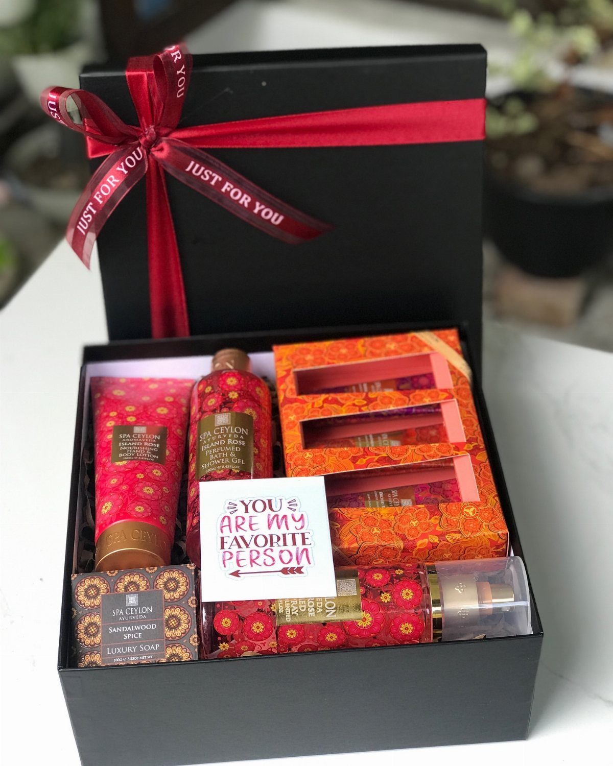 Bath and body gift set in a black box with a red ribbon.