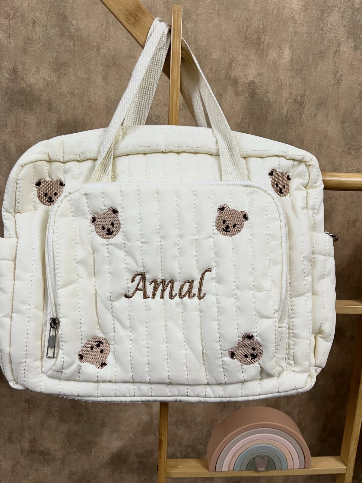 White quilted diaper bag with teddy bear embroidery and personalized name Amal.