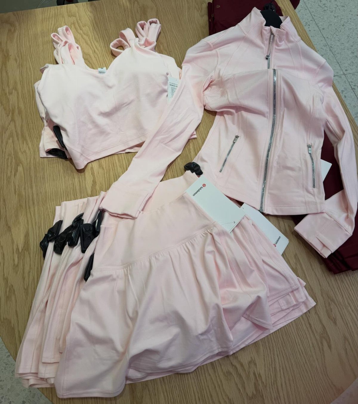 Light pink matching athletic set with cropped top, jacket, and pleated skirt.