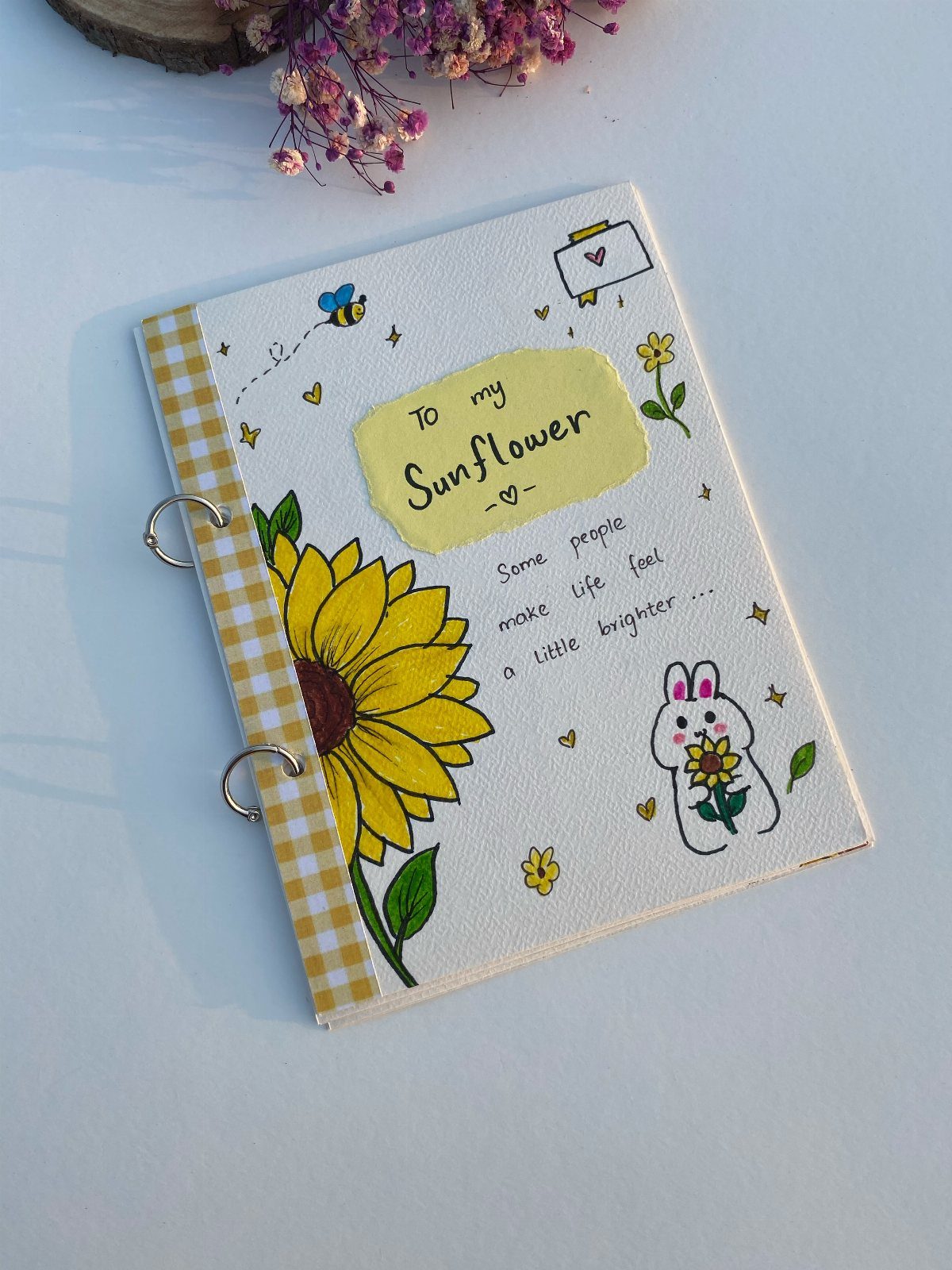 Hand-drawn journal with a sunflower and bunny on a white fabric cover