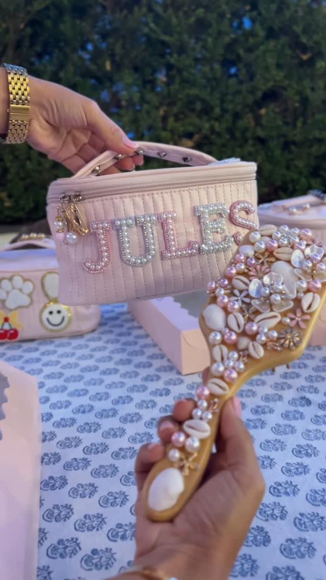 Pink quilted makeup bag with pearl lettering and a matching pearl-encrusted hand mirror.