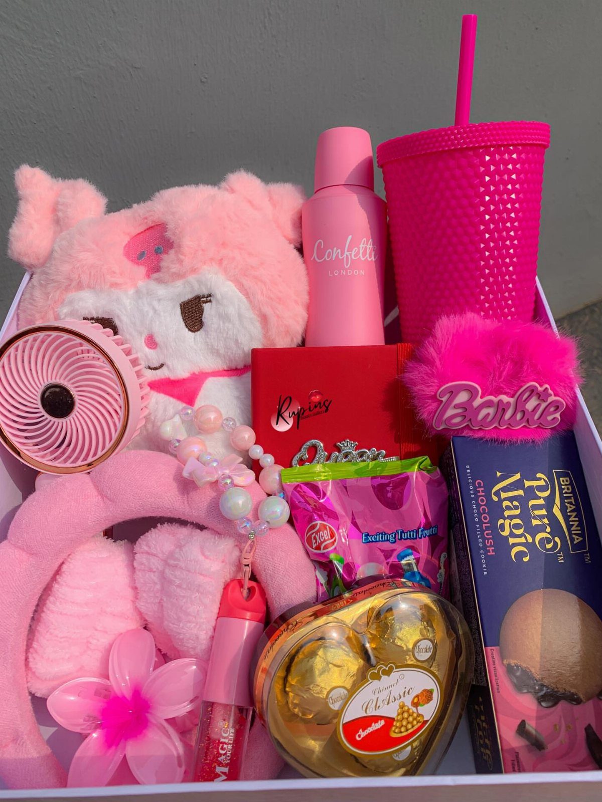 Pink themed gift box containing a plush toy, tumbler, and chocolates for Valentine's Day.