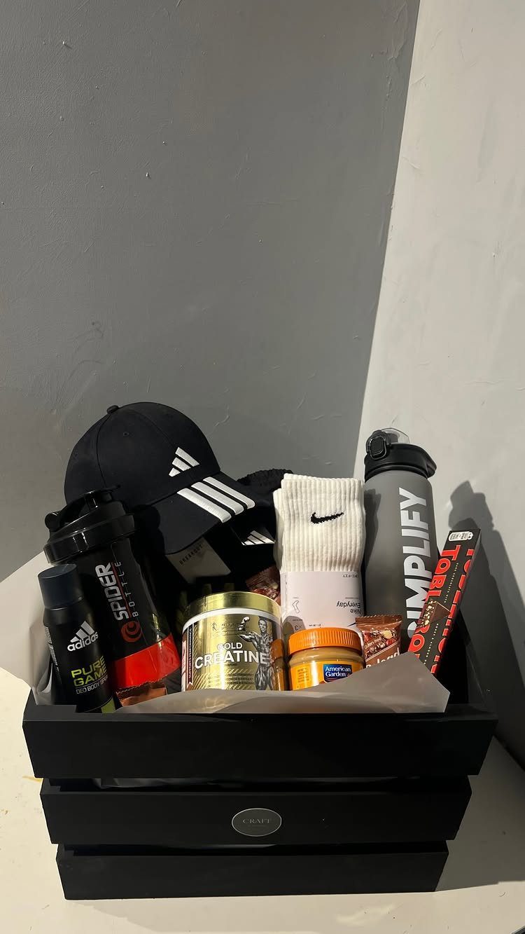 Fitness gift basket with Adidas cap, Nike socks, water bottle, and workout supplements.