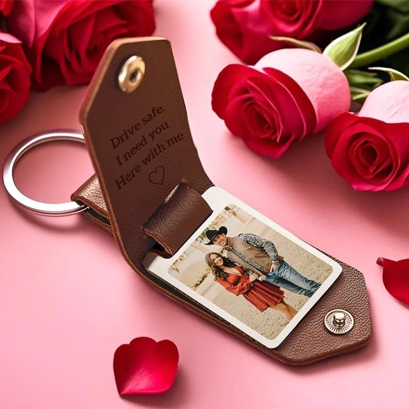 Brown leather keychain with a couple's photo and engraved message among red roses.