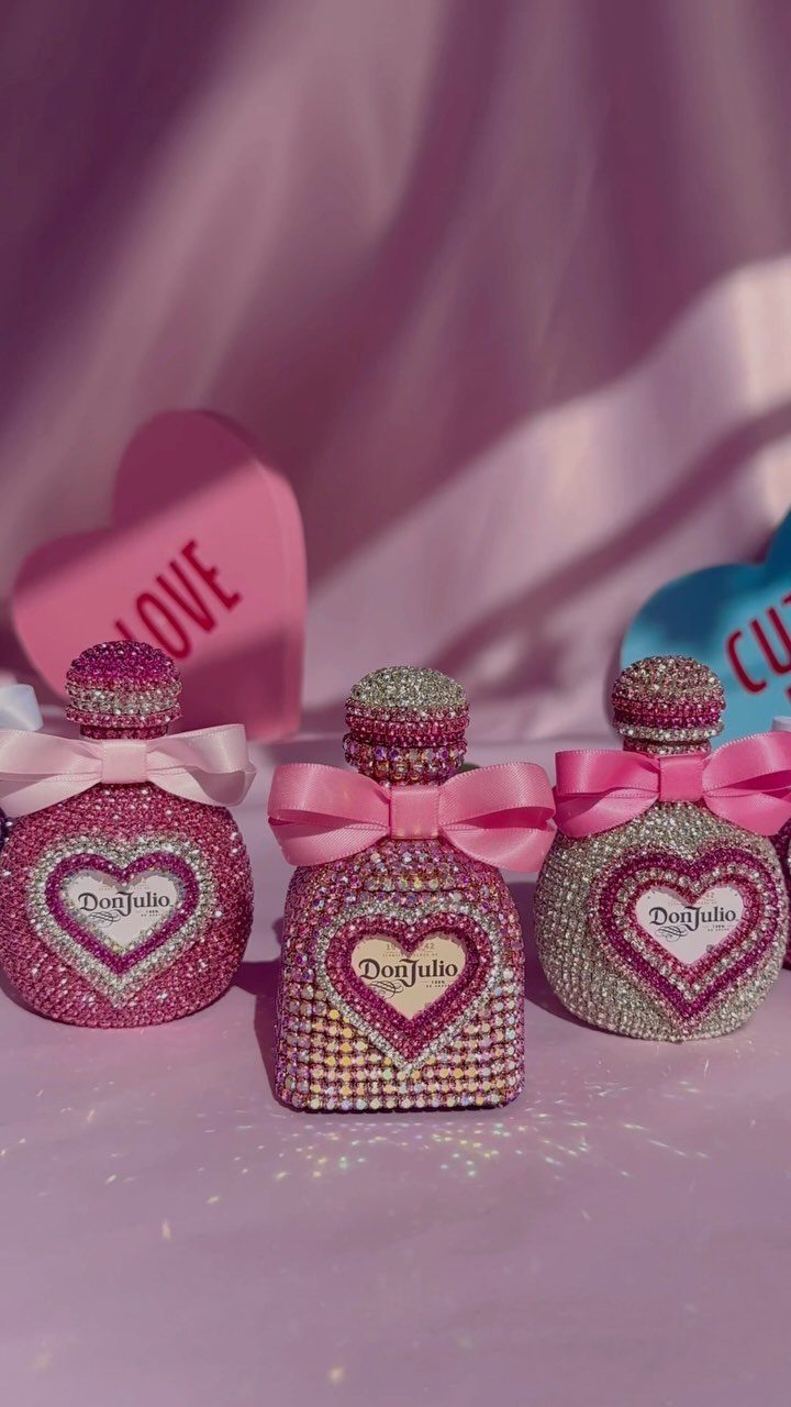 Rhinestone covered Don Julio tequila bottles with pink bows and heart decorations.