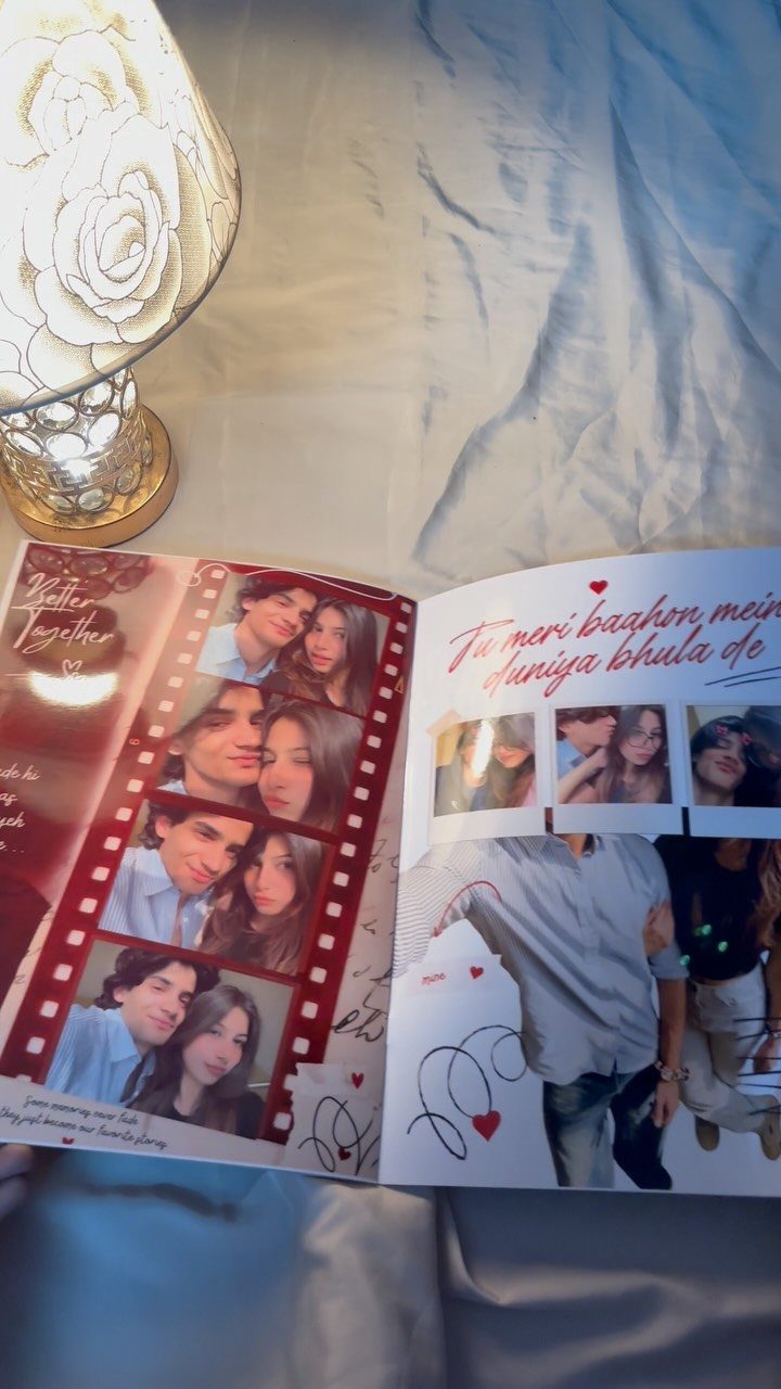 Open scrapbook with photos of a couple, red hearts, and handwritten romantic messages.