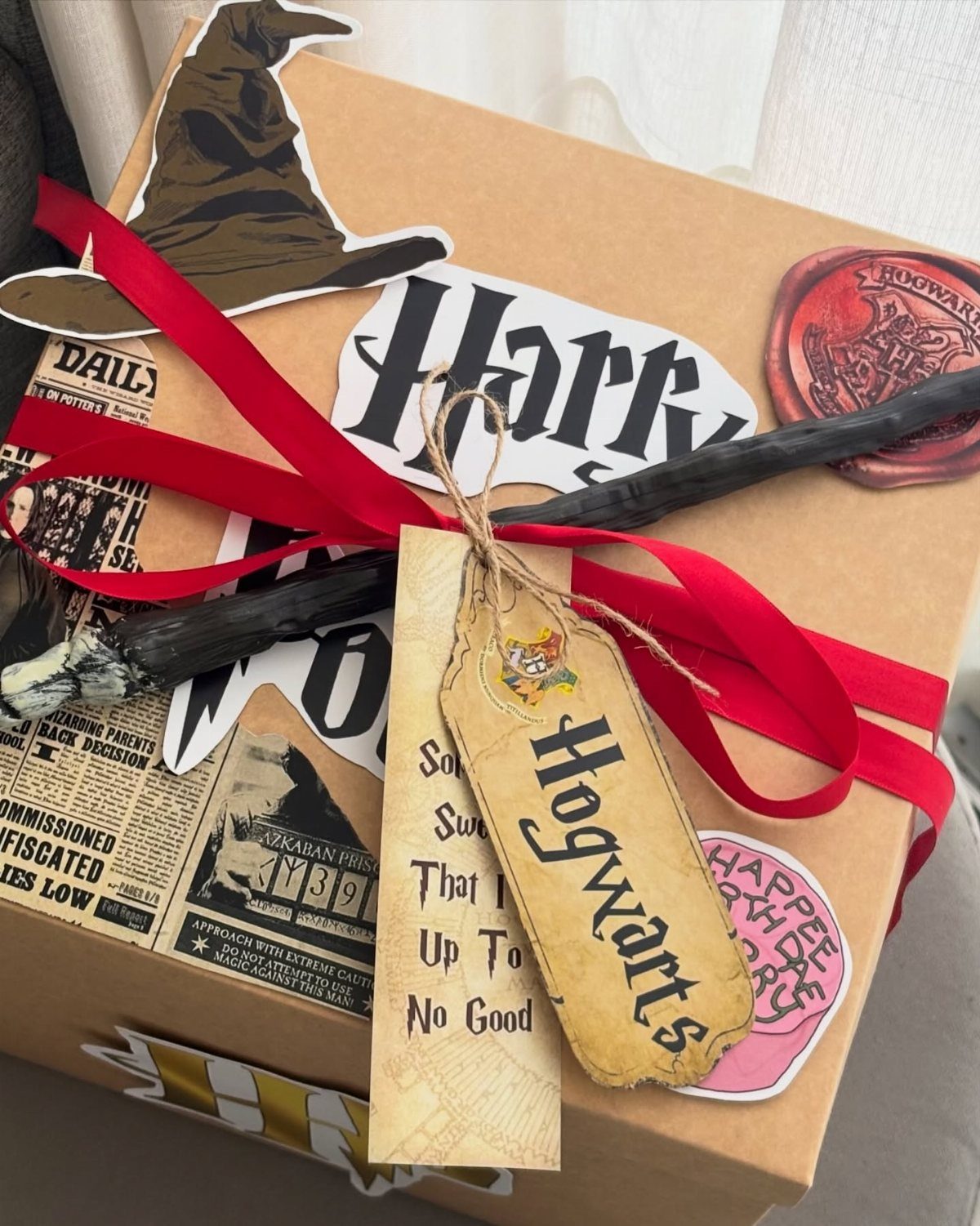 25 Best Harry Potter Gifts for Every Wizarding Fan in 2026 15 Wrapped gift box decorated with Harry Potter stickers, a wand, and Hogwarts tags.