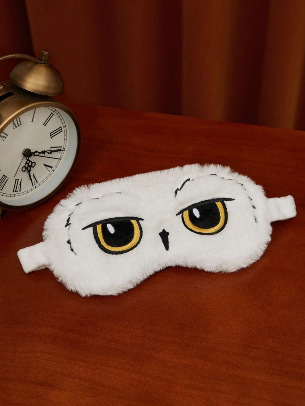 25 Best Harry Potter Gifts for Every Wizarding Fan in 2026 23 White fluffy owl sleep mask and vintage brass alarm clock on wooden table