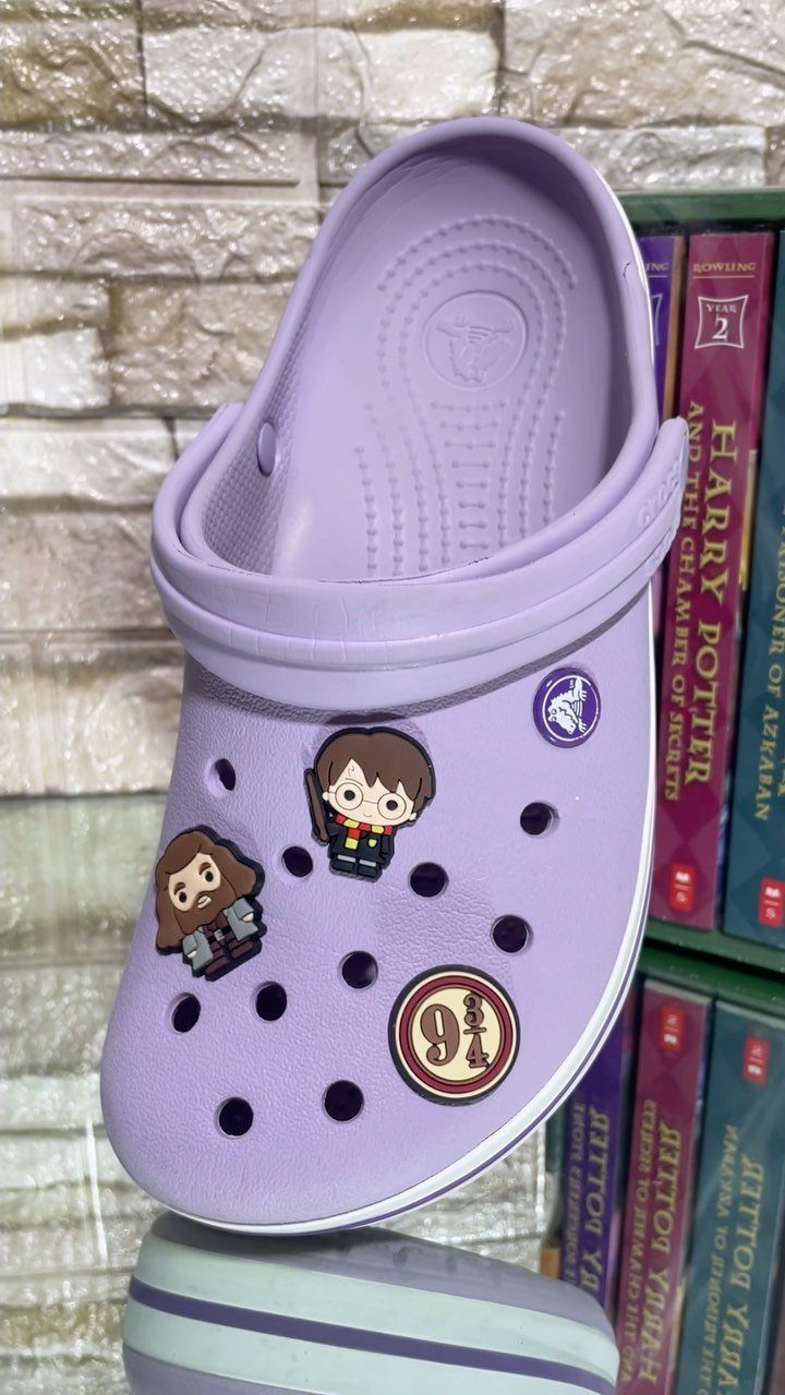 25 Best Harry Potter Gifts for Every Wizarding Fan in 2026 11 Purple Croc shoe decorated with Harry Potter character charms and Platform 9 3/4 logo.