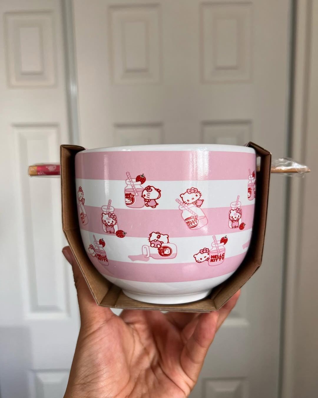 Hello Kitty ceramic bowl with pink stripes held in a hand