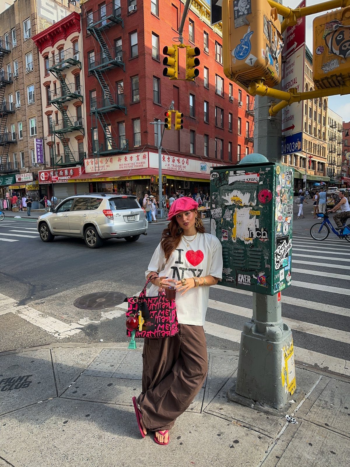 Woman in I Love NY t-shirt holding a pink tote bag on NYC street