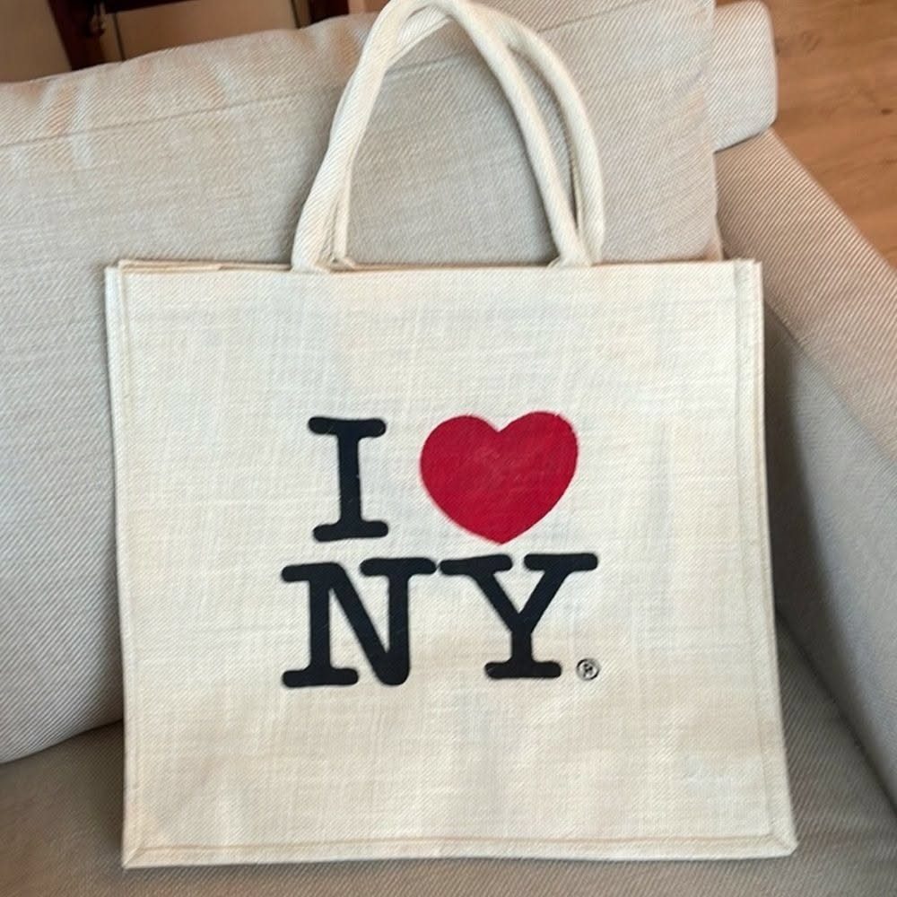 White canvas tote bag with I Love NY logo resting on a sofa