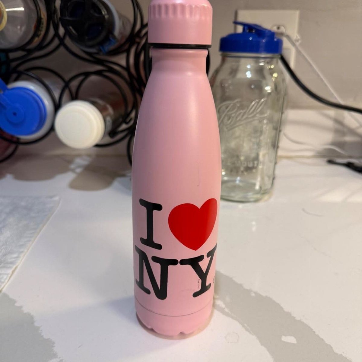 Pink water bottle featuring the I Love NY logo on a white surface.