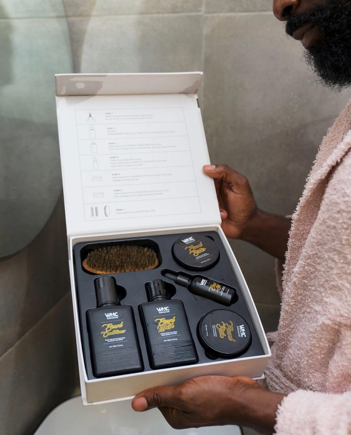 20 Ideal Boyfriend Gifts He'll Actually Use and Keep 2 Man holding an open white box containing a complete beard grooming kit.