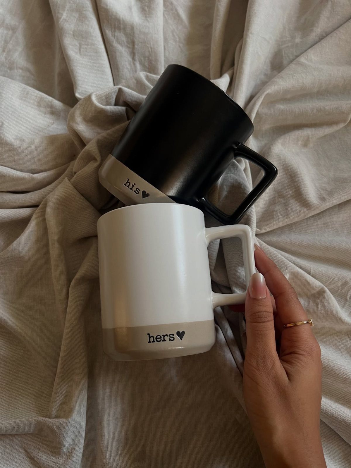 20 Ideal Boyfriend Gifts He'll Actually Use and Keep 12 Two ceramic mugs labeled his and hers resting on beige fabric.