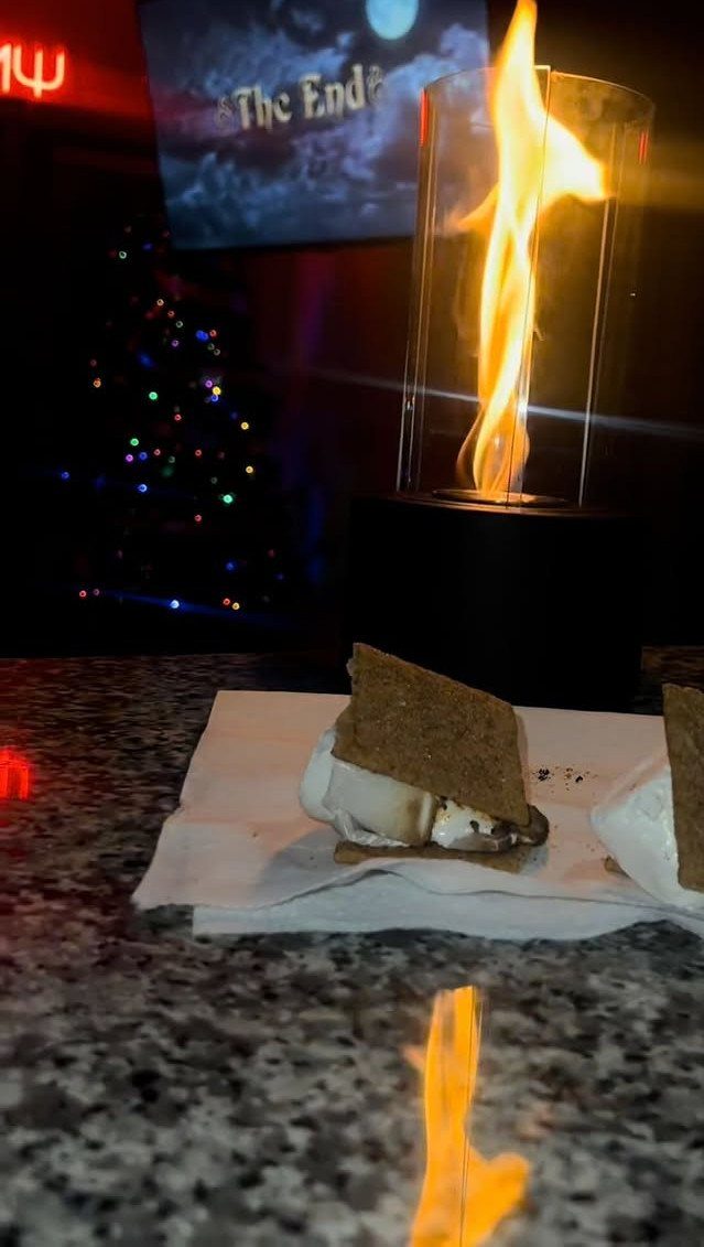 20 Ideal Boyfriend Gifts He'll Actually Use and Keep 1 Tabletop fire pit with a flame and a toasted s'more on a counter