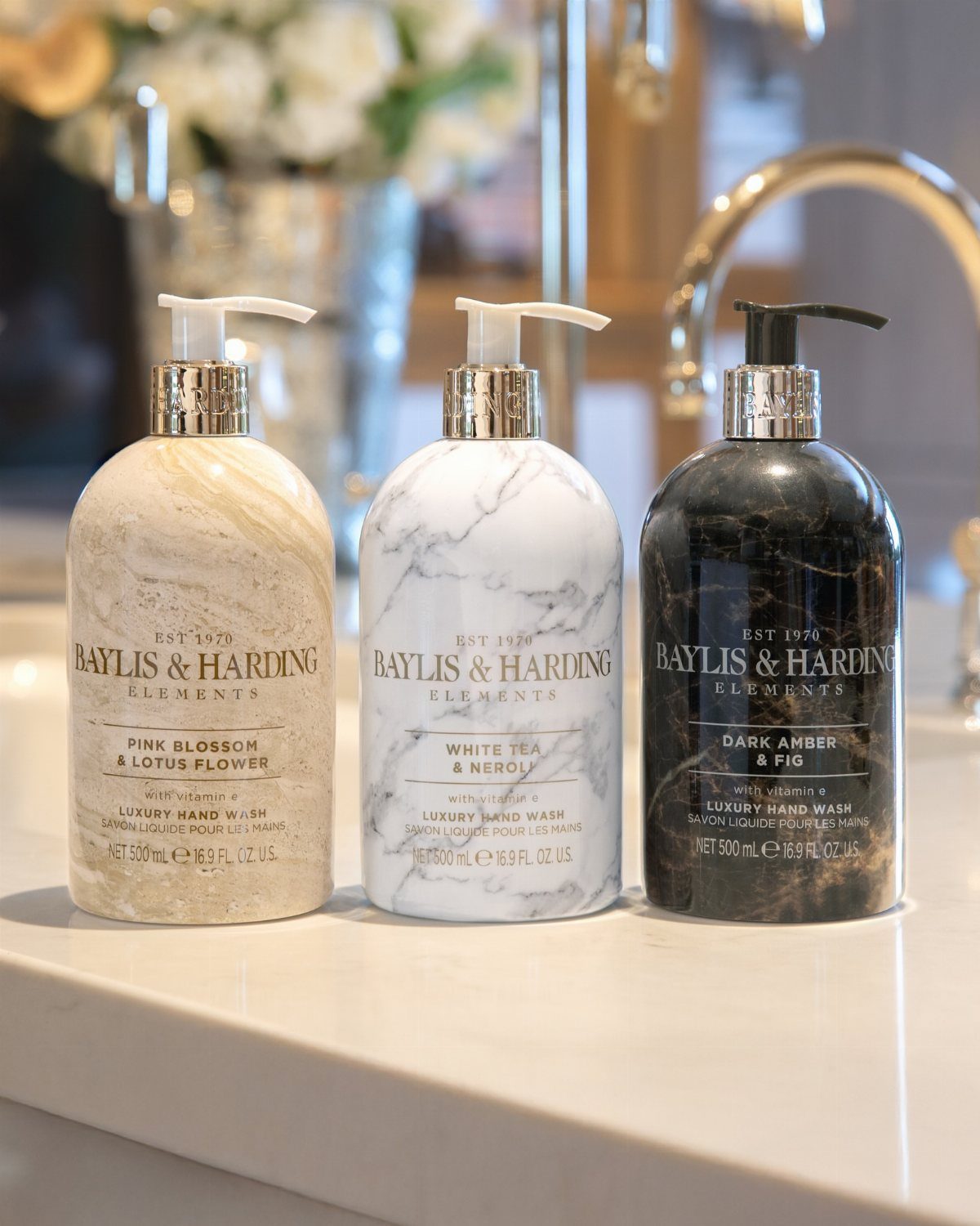 Luxury Gifts for Women: 11 Ideas from Candles to Jewelry 1 Three marble-patterned hand soap bottles on a white marble bathroom counter.