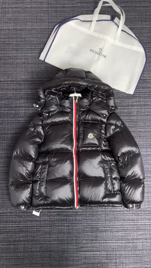 Luxury Gifts for Women: 11 Ideas from Candles to Jewelry 11 Black Moncler puffer jacket and white branded shopping bag on grey textured background