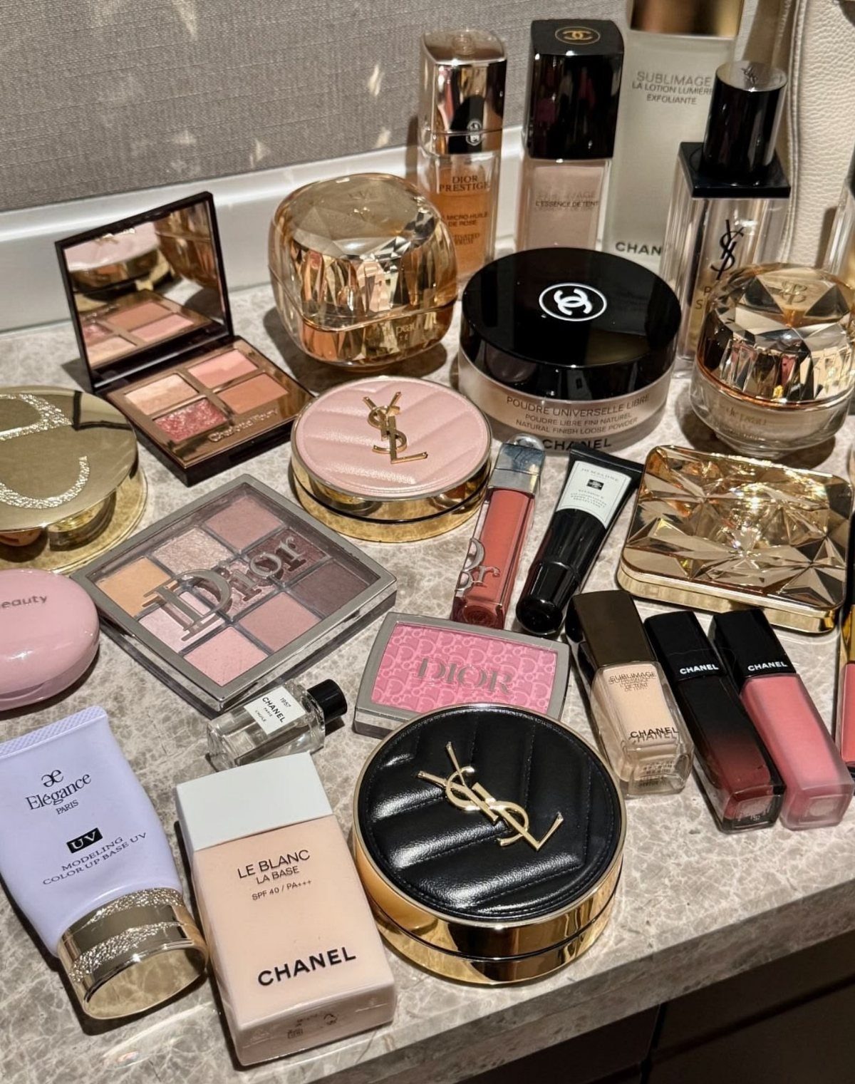 Luxury Gifts for Women: 11 Ideas from Candles to Jewelry 5 Luxury makeup and skincare products from Chanel, Dior, and YSL on a table.