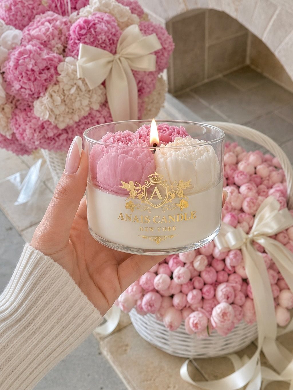 Luxury Gifts for Women: 11 Ideas from Candles to Jewelry 2 Lit luxury candle with pink floral wax toppers held against pink flower baskets.