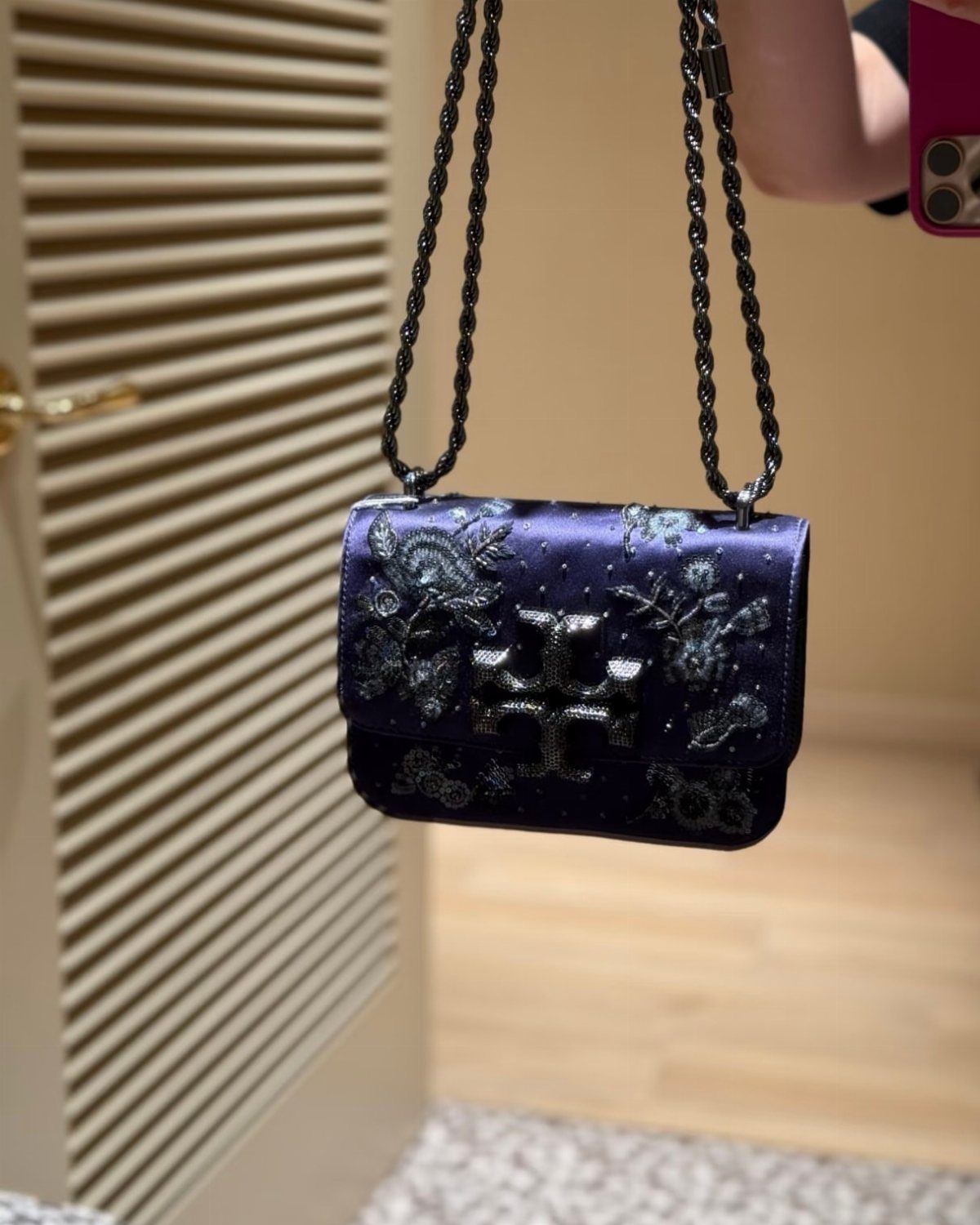 Dark purple satin handbag with floral embroidery and a black chain strap.