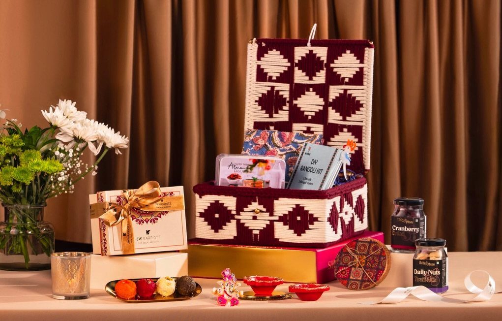 Luxury gift hamper with gourmet treats and jars in a patterned fabric box.