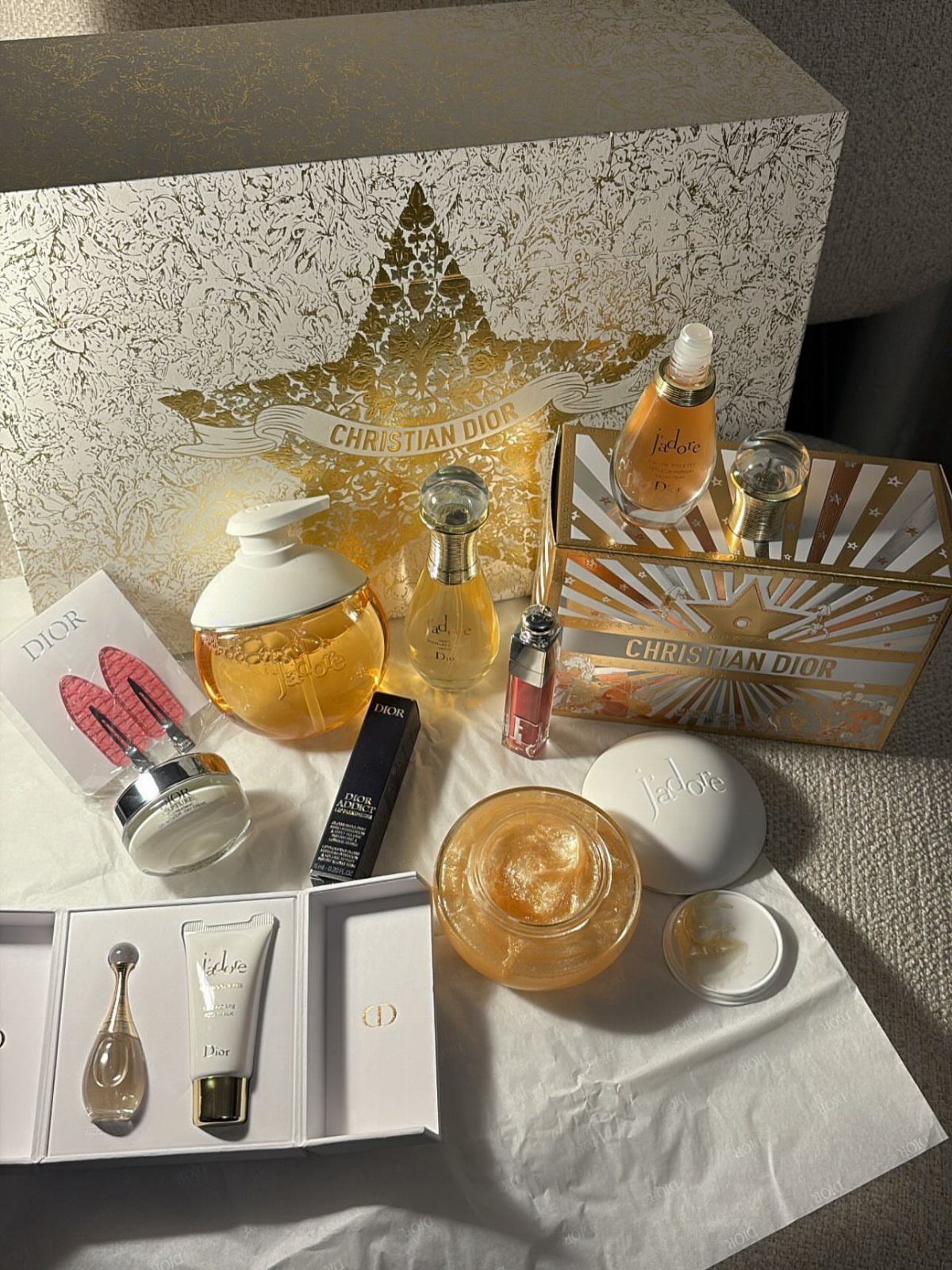 Christian Dior J'adore perfume gift set with gold bottles and skincare products.