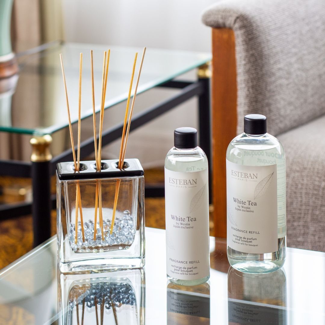 Westin White Tea reed diffuser and refill bottles on a glass table