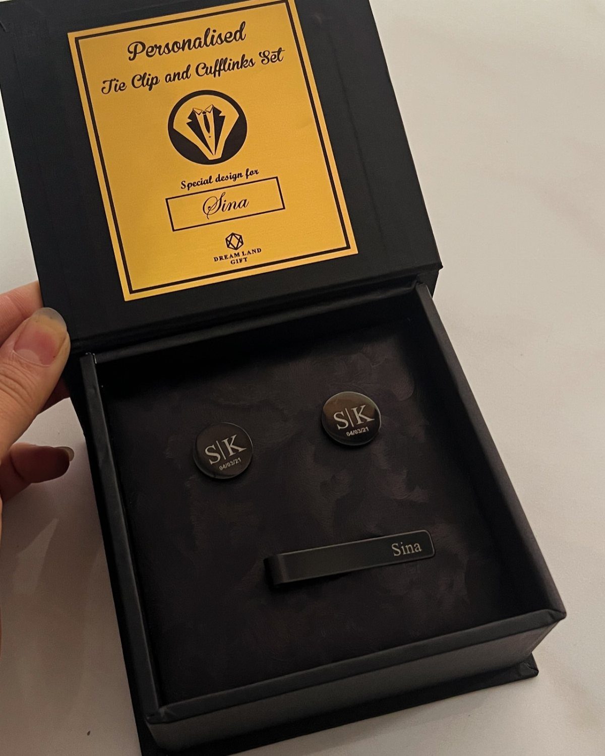 Black engraved tie clip and cufflinks set inside a black gift box
