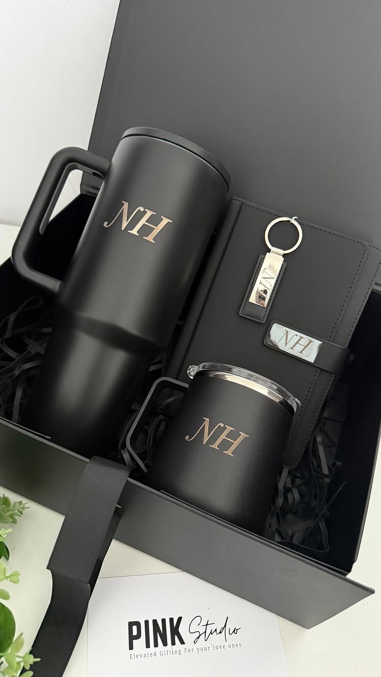Black gift set with travel mug and notebook featuring gold NH monogram