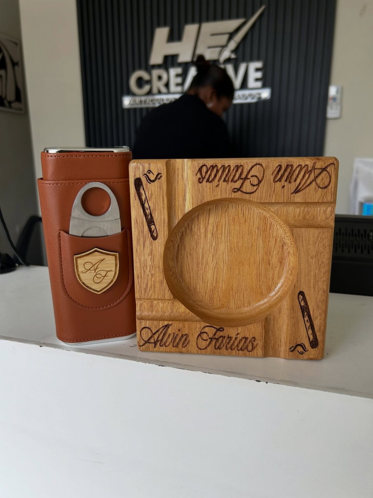 Leather cigar case and wooden ashtray both personalized with names and monograms.