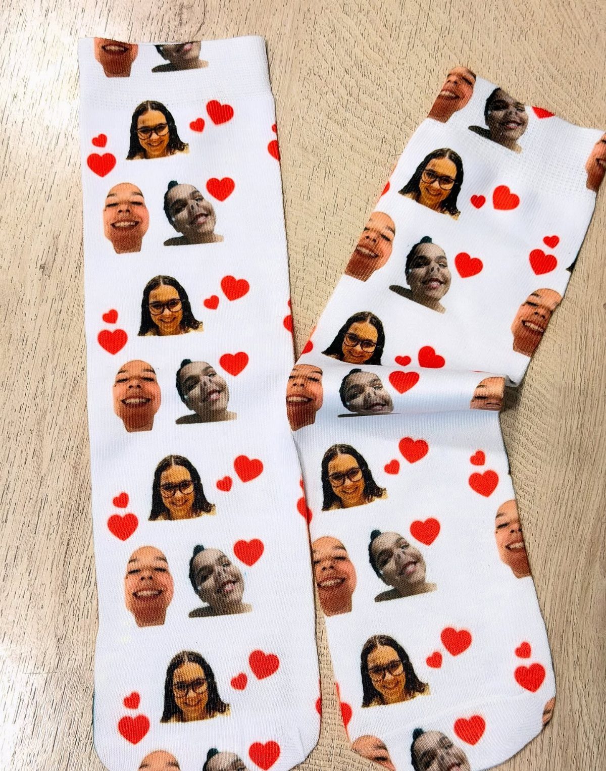 White socks with a repeating pattern of female face photos and red hearts.