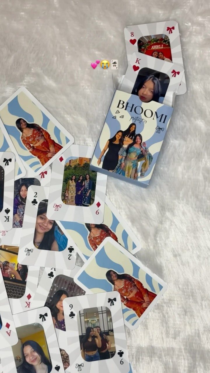 Custom playing cards with personal photos scattered on a white faux-fur background.