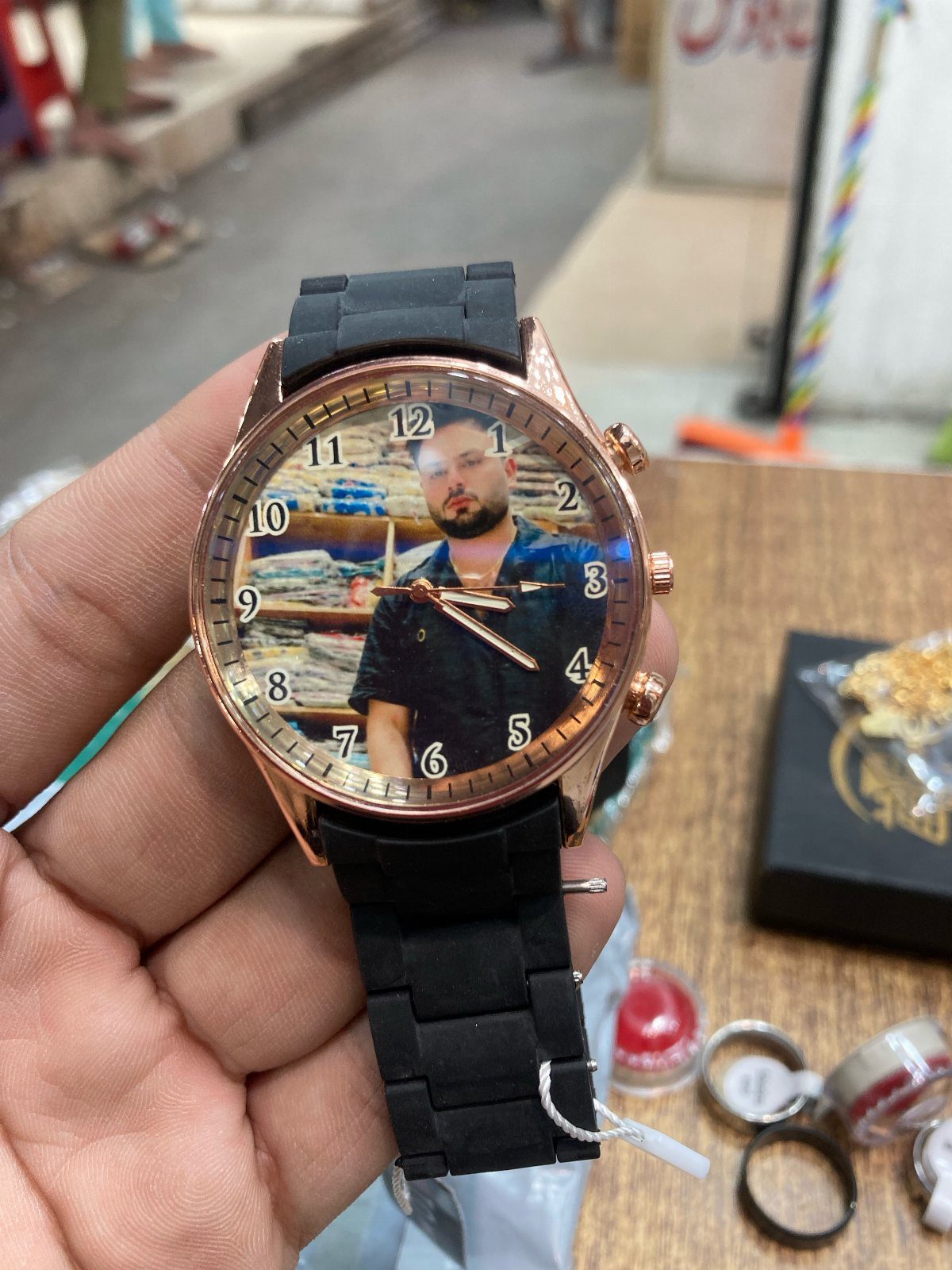 Rose-gold wristwatch with a black strap featuring a personalized photo on the watch face.