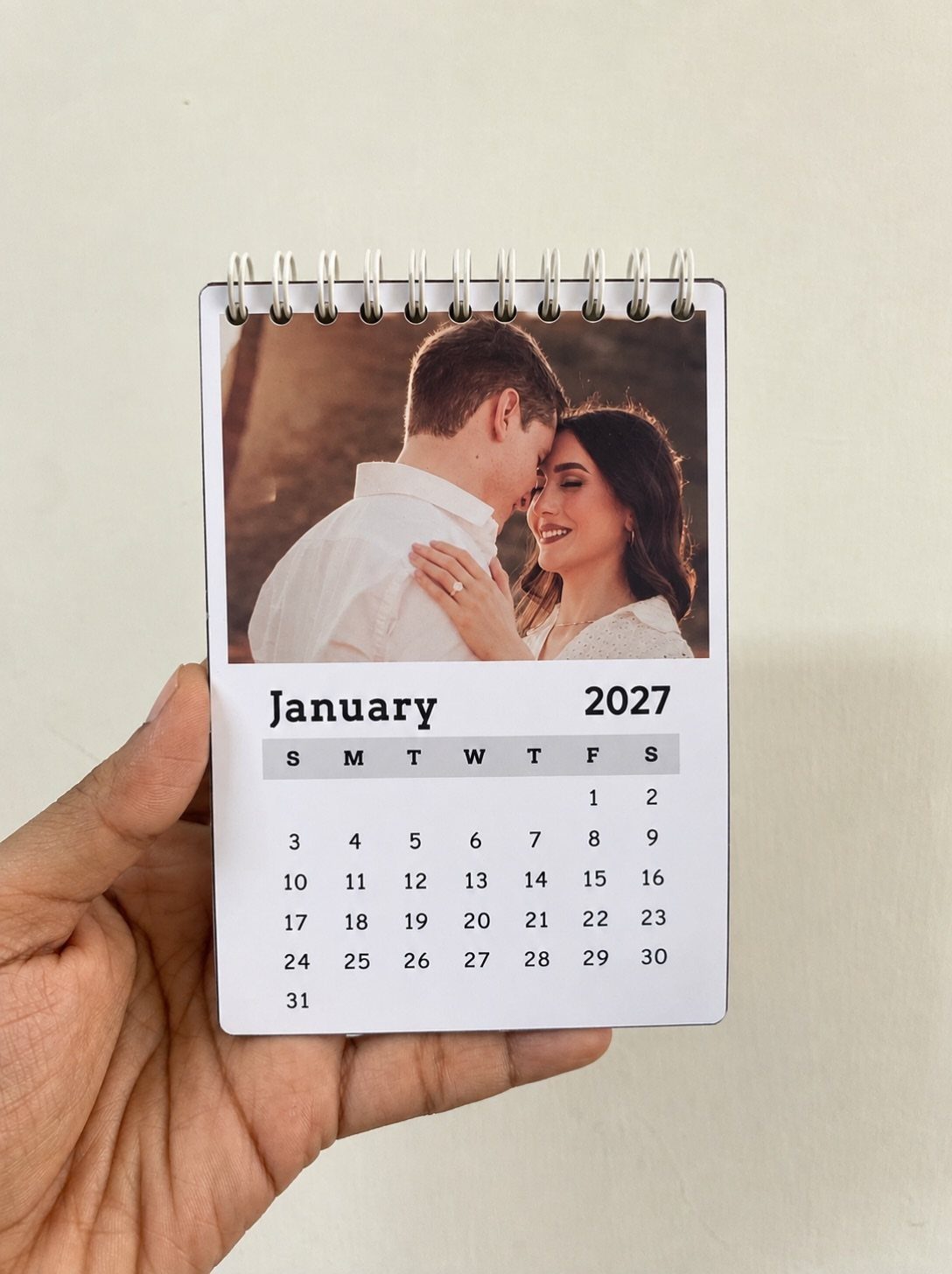 Spiral-bound desk calendar featuring a personalized photo of a couple for January 2027.