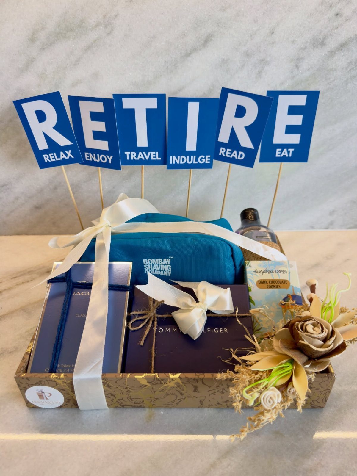 Retirement gift hamper for men with blue accessories and RETIRE signs on sticks.
