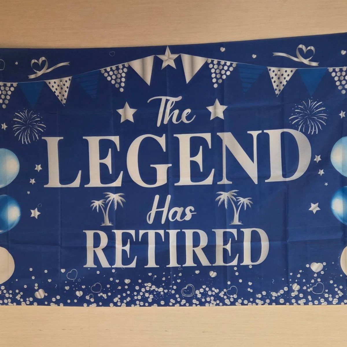 Blue retirement banner with white text reading The Legend Has Retired and decorations.
